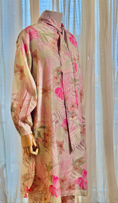 Floral patterned coat on a mannequin against a sheer curtain background