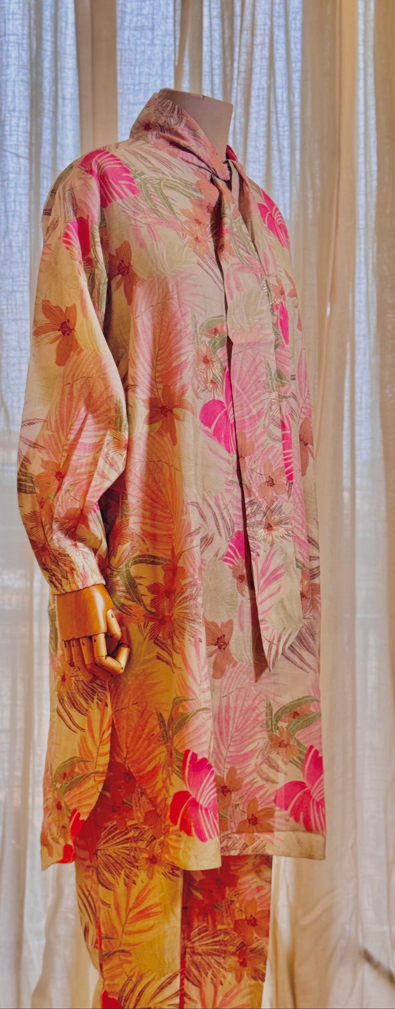 Colorful floral outfit on a mannequin against a sheer curtain background