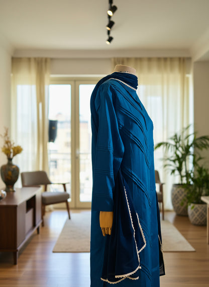 Blue dress on a mannequin in front of sheer curtains
