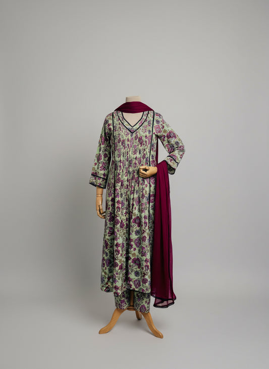 Mannequin wearing a floral dress with a red shawl against a white curtain background