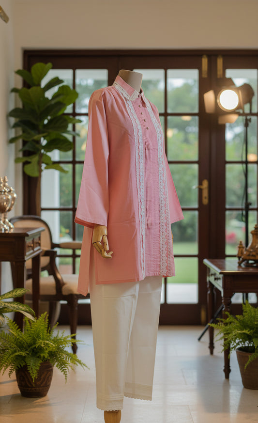 Mannequin wearing a pink and white traditional outfit in front of sheer curtains.