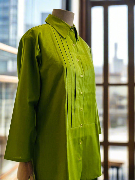 Green shirt on a mannequin against a white curtain background